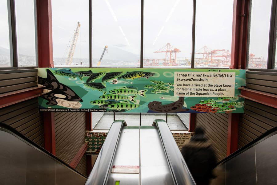 Indigenous art and signage above escalators in SeaBus terminal at Waterfront Station