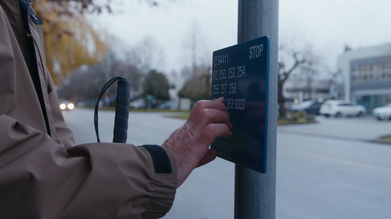 A blind man reading a tactile bus stop sign