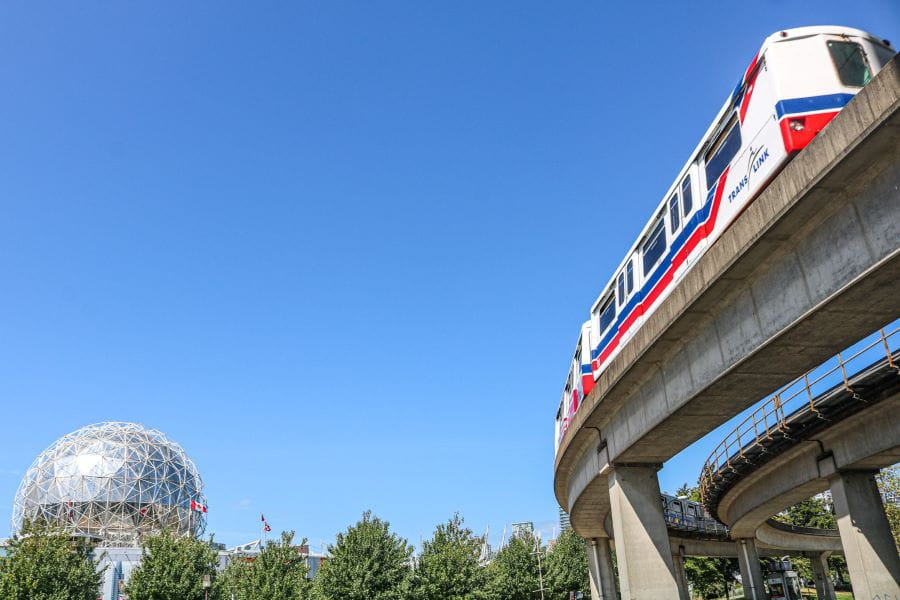 SkyTrain passing by Science World on sunny day