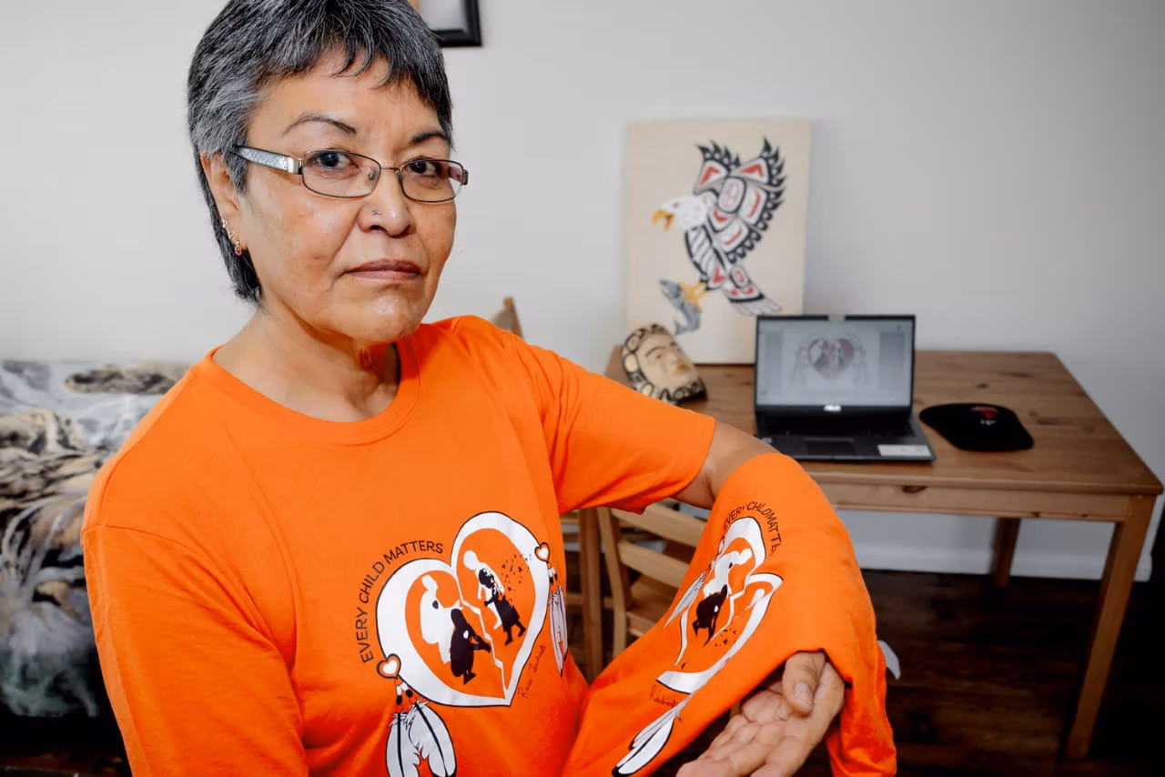 Taltan Tlingit Nation, Wolf Clan artist Rose Tashoots proudly wearing and displaying the orange shirt she helped to design