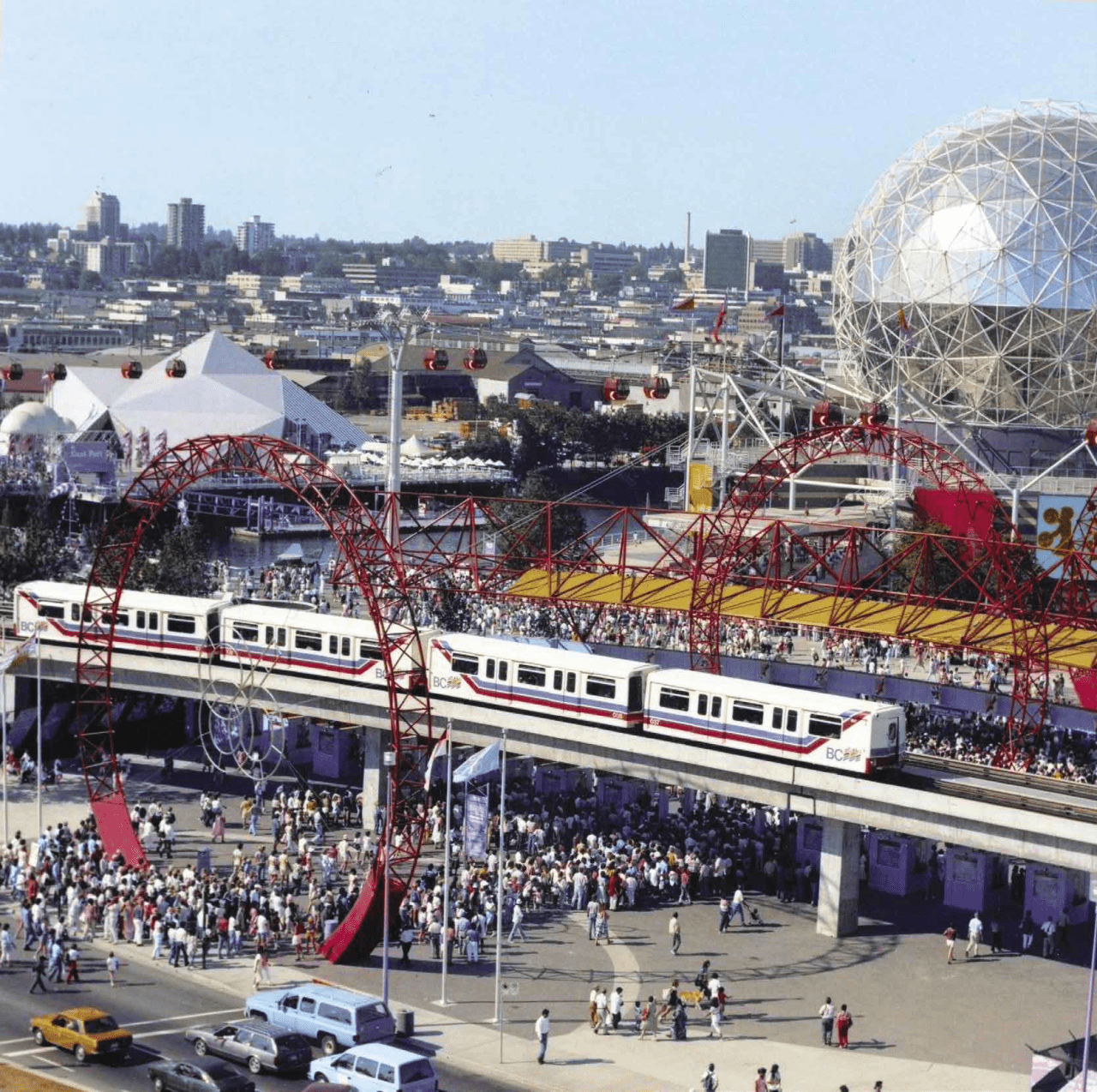 Mark I SkyTrain passes by a crowd standing outside what is now called Science World during Expo 86
