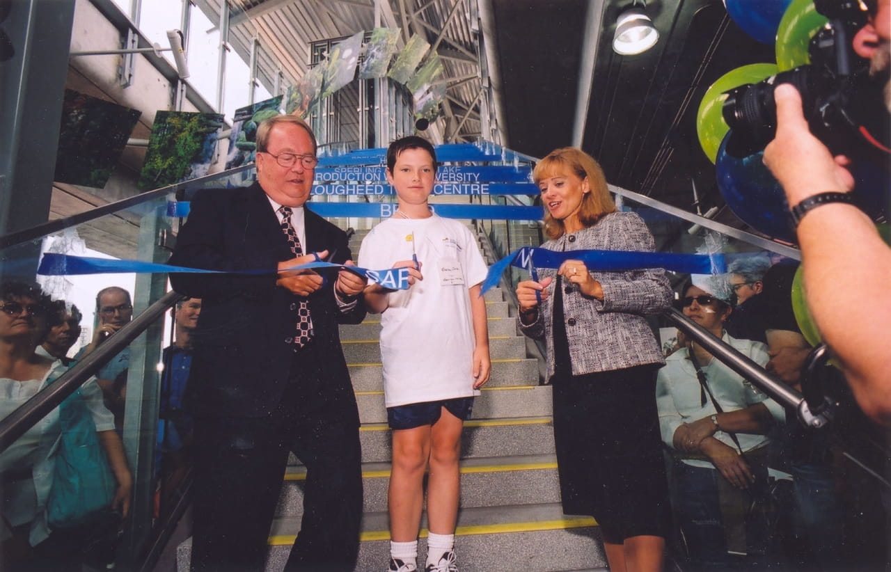 Politicians surround a young child as they cut the ribbon to officially open the Millennium Line during the opening ceremony