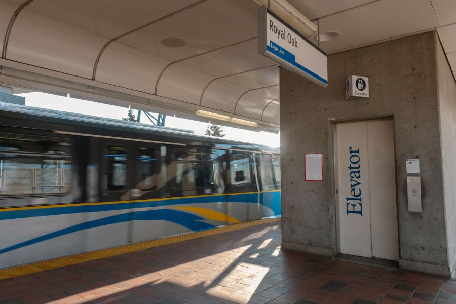 Royal Oak Station elevator on platform with SkyTrain passing by