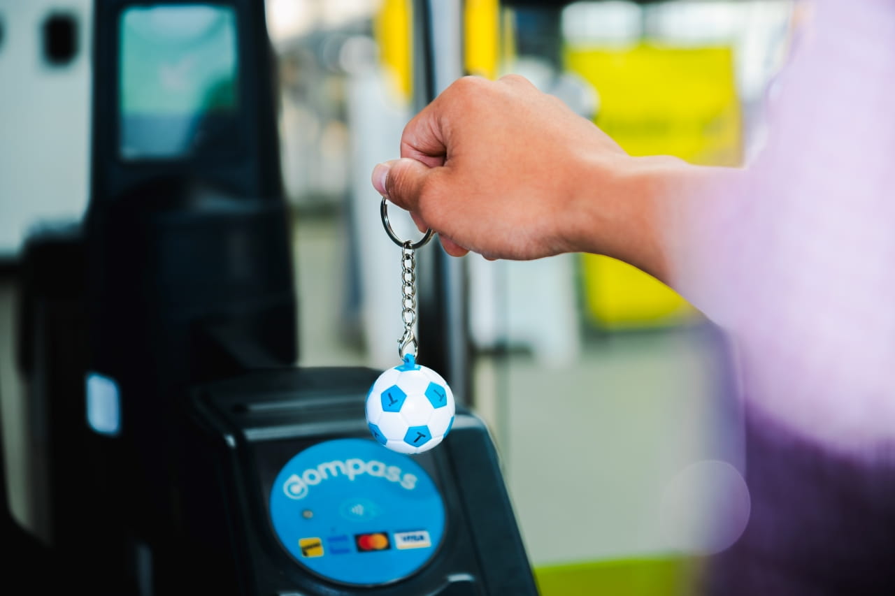 The new Compass Soccer Mini is shown tapping in at a fare gate at a SkyTrain station.