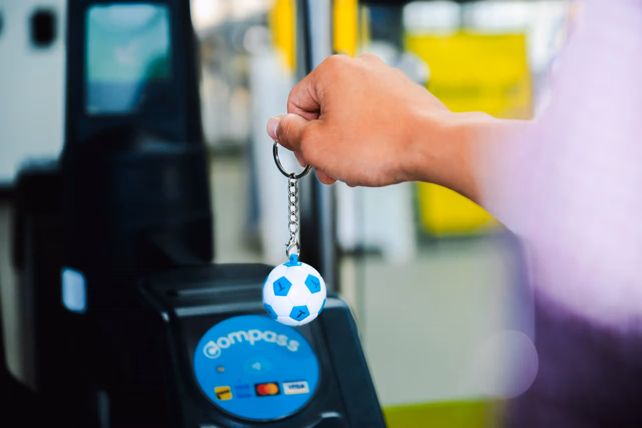 The new Compass Soccer Mini is shown tapping in at a fare gate at a SkyTrain station.