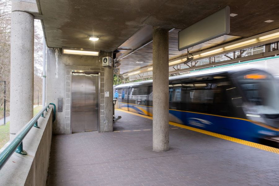 Edmonds Station elevator with SkyTrain passing by empty platform