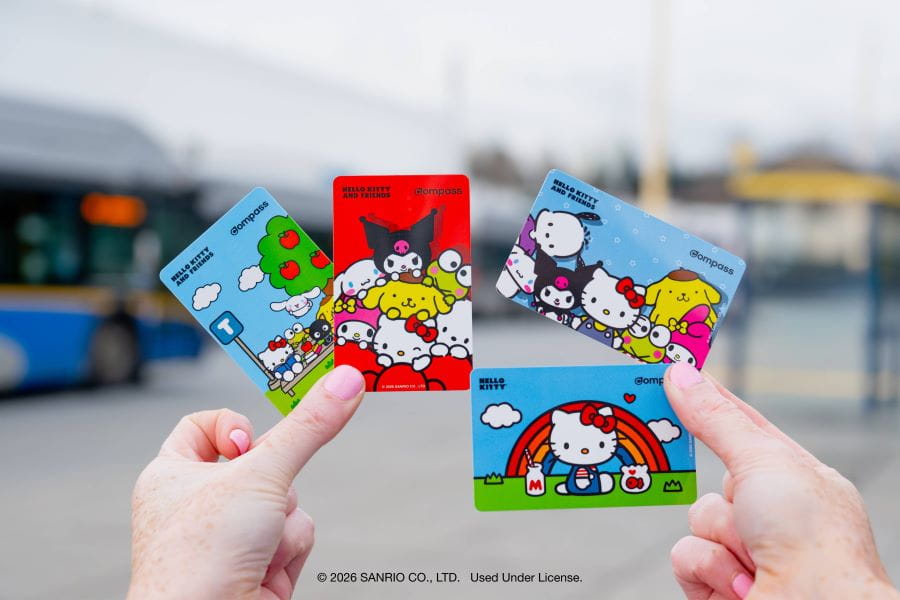Hands holding four Hello Kitty-themed Compass Cards