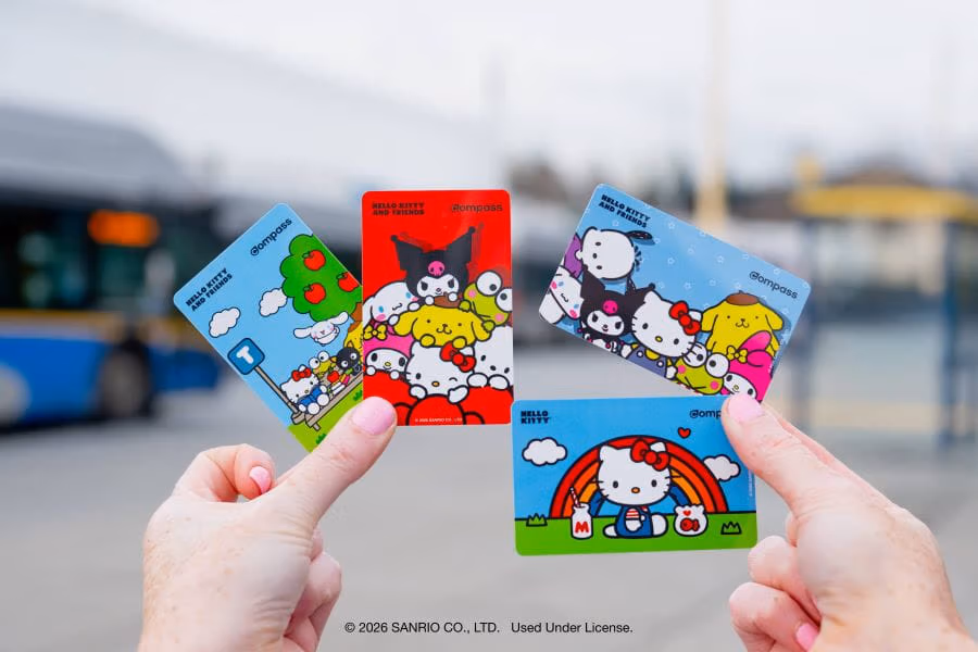 Hands holding four Hello Kitty-themed Compass Cards