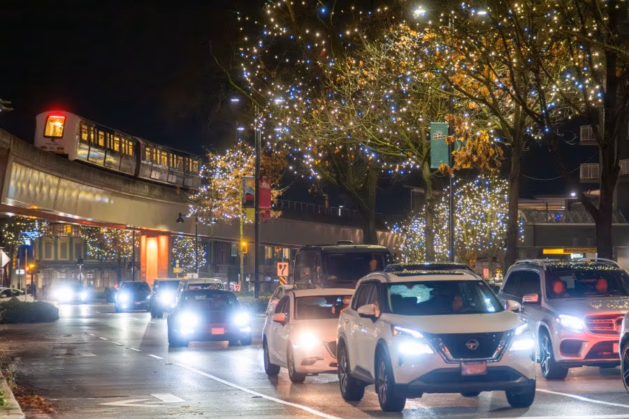 SkyTrain passing over busy road with cars at night