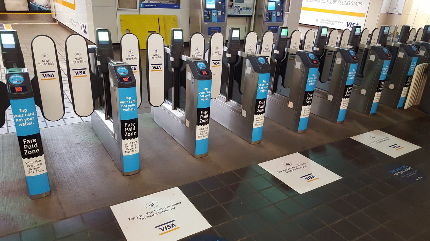Closed fare gates displaying signs promoting Tap to Pay
