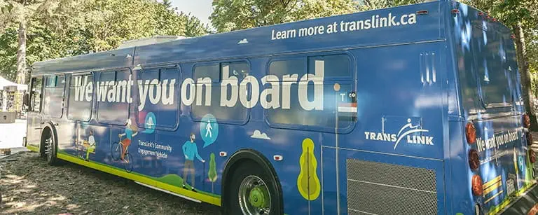 A bus wrapped with a blue advertising message